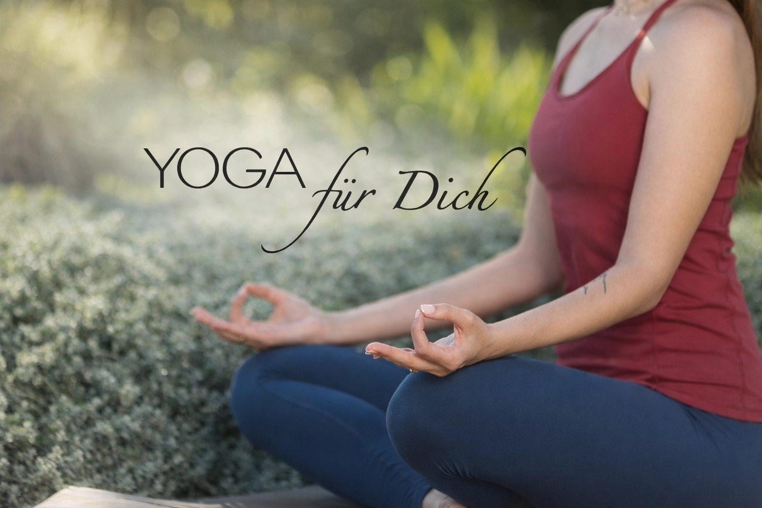 Yoga für Dich - Yoga Kurse - Eine Person sitzt in einer Meditationshaltung mit gekreuzten Beinen auf einer Matte; im verschwommenen Hintergrund sind brennende Kerzen zu sehen.